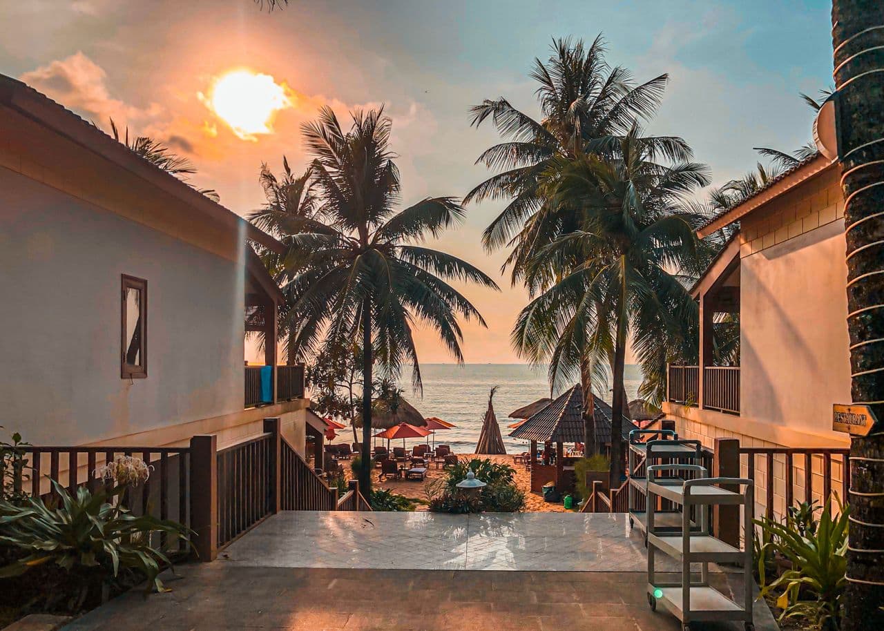 Hàng dừa và hai dãy nhà hướng ra biển trong ánh hoàng hôn