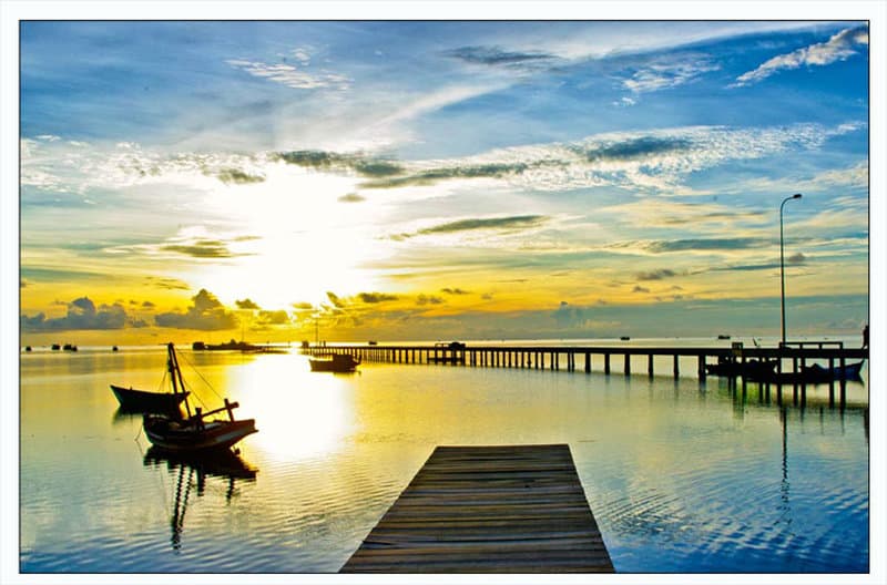 Thuyền nhỏ và cầu bến dưới trời sáng trên biển Hàm Ninh
