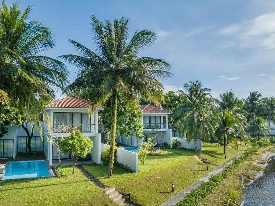 Các biệt thự hai tầng mái ngói đỏ, mỗi căn có hồ bơi nhỏ, nằm dọc bờ hồ giữa hàng dừa.
